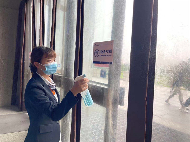 值守人员对出入口门帘消毒.jpg