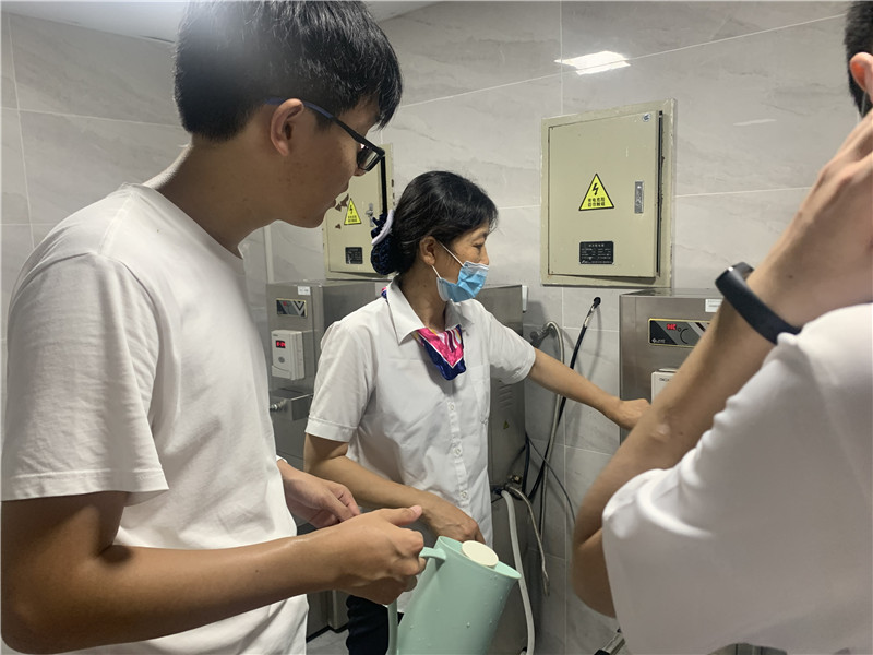 值班员引导学生开水炉使用.jpg