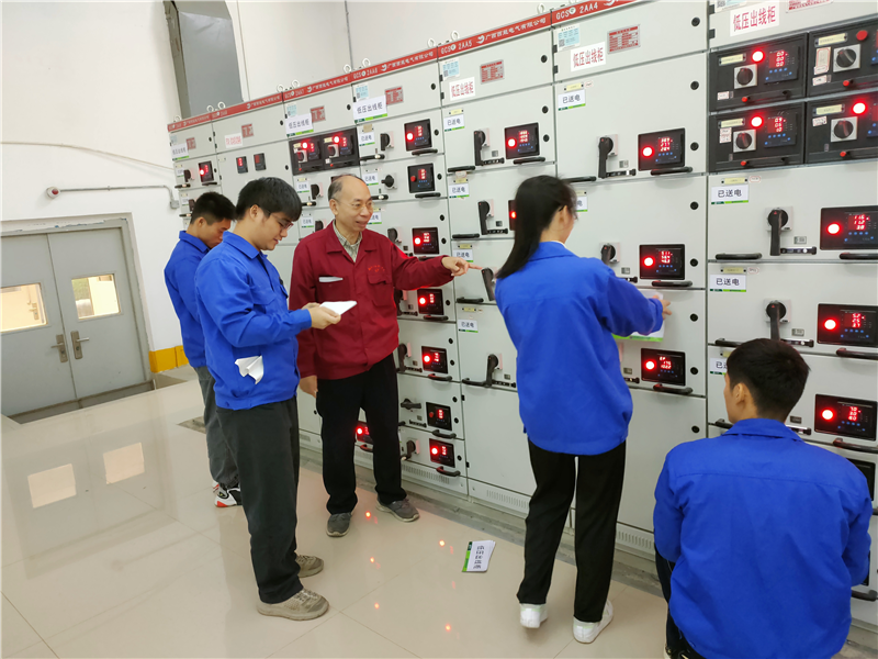 潘老师指导学生在变电房的高低压电气设备张贴标准化的标识.png