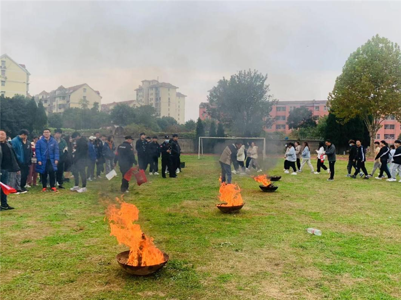 学生在操场集合准备使用干粉灭火器喷灭火源.png