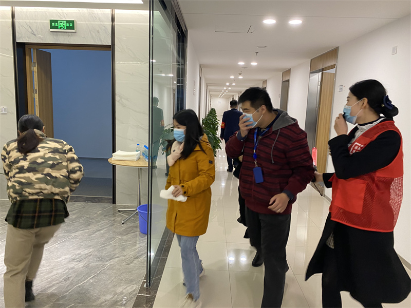 物业工作人员指引各办公室人员及时撤离.jpg