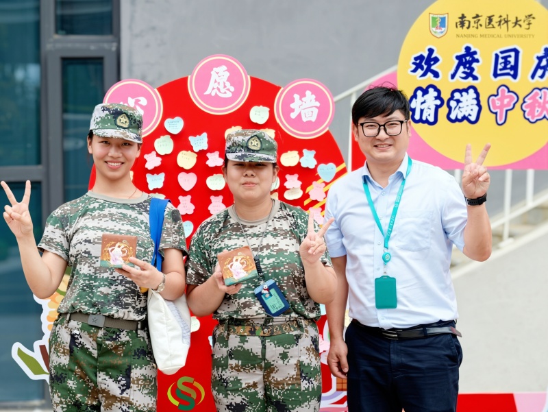 1790384499941195.jpg 学生与物业管理人员在心愿墙前合影.jpg